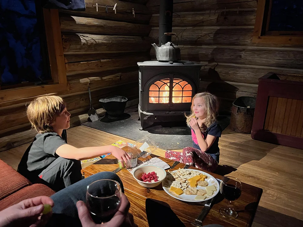 Ely, MN - Kids having a snack in front of a fire at Sundew Cabin