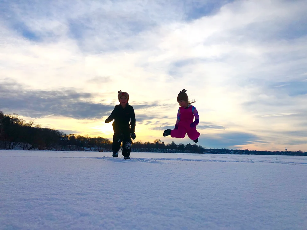 Best ice fishing lakes in MN - Kids jumping with the sunset in the background