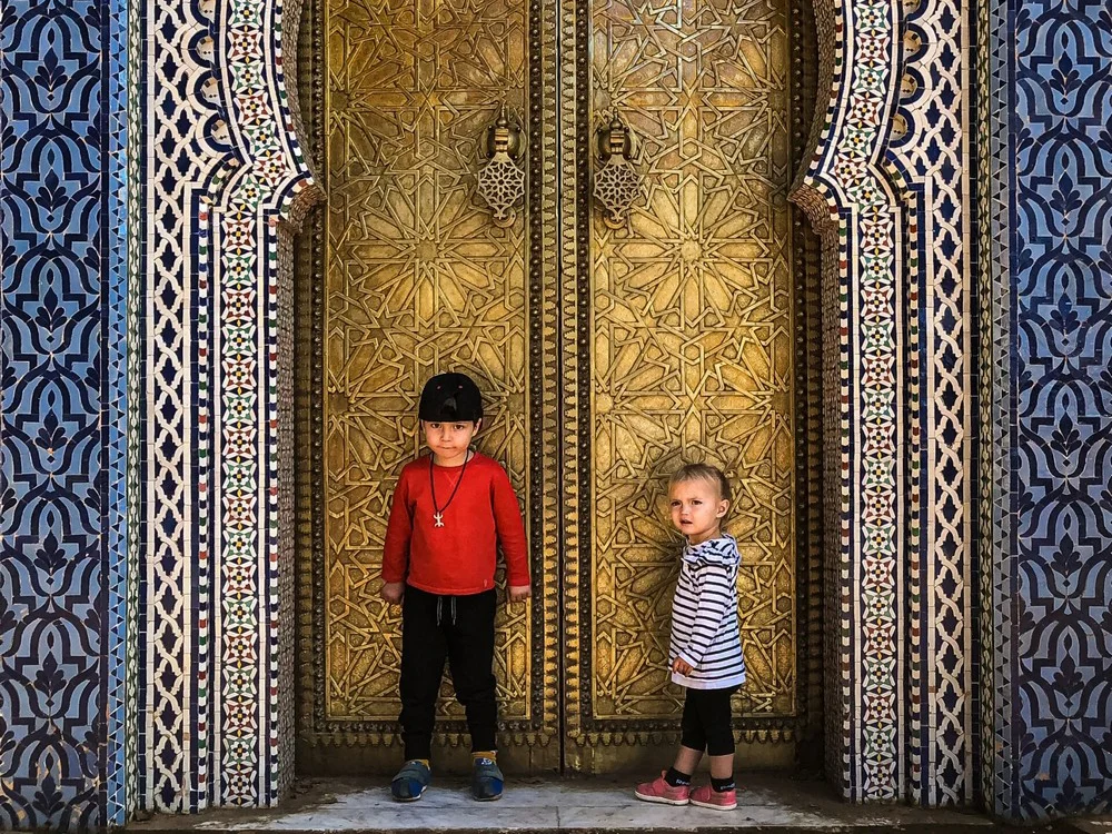 Morocco - Brother and sister standing in front of the main gate at the Royal Palace in the Jewish Quarter of Fez